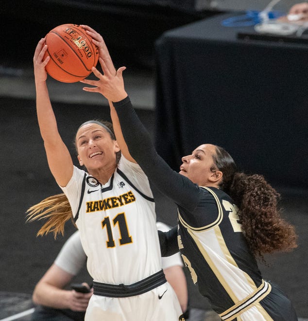 Iowa Hawkeyes guard Megan Meyer (11) grabs a defensive rebound as she works against Purdue Boilermakers guard Kayana Traylor (23) on Wednesday, March 10, 2021, during the women's Big Ten basketball tournament from Bankers Life Fieldhouse in Indianapolis.