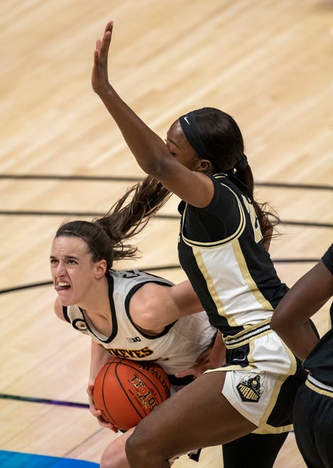 Iowa Hawkeyes guard Caitlin Clark (22) works for a shot opportunity as she is defended by Purdue Boilermakers guard Tamara Farquhar (25) on Wednesday, March 10, 2021, during the women's Big Ten basketball tournament from Bankers Life Fieldhouse in Indianapolis.