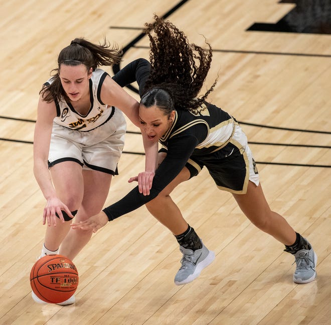 Iowa Hawkeyes guard Caitlin Clark (22) battles for a loose ball knocked away by Purdue Boilermakers guard Kayana Traylor (23) on Wednesday, March 10, 2021, during the women's Big Ten basketball tournament from Bankers Life Fieldhouse in Indianapolis. Iowa won 83-72.