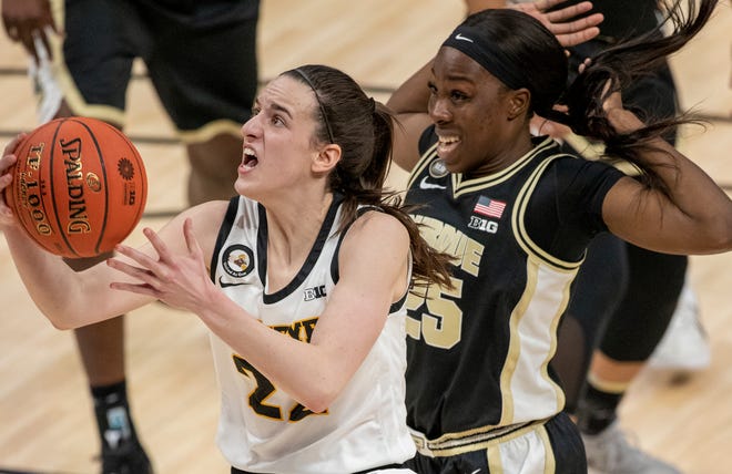 Iowa Hawkeyes guard Caitlin Clark (22) drives to the hoop as Purdue Boilermakers guard Tamara Farquhar (25) trails on Wednesday, March 10, 2021, during the women's Big Ten basketball tournament from Bankers Life Fieldhouse in Indianapolis.