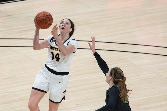 Mar 12, 2021; Indianapolis, IN, USA; Iowa Hawkeyes guard McKenna Warnock (14) shoots the ball while Michigan State Spartans forward Kendall Bostic (44) defends  in the fourth quarter at Bankers Life Fieldhouse. Mandatory Credit: Trevor Ruszkowski-USA TODAY Sports