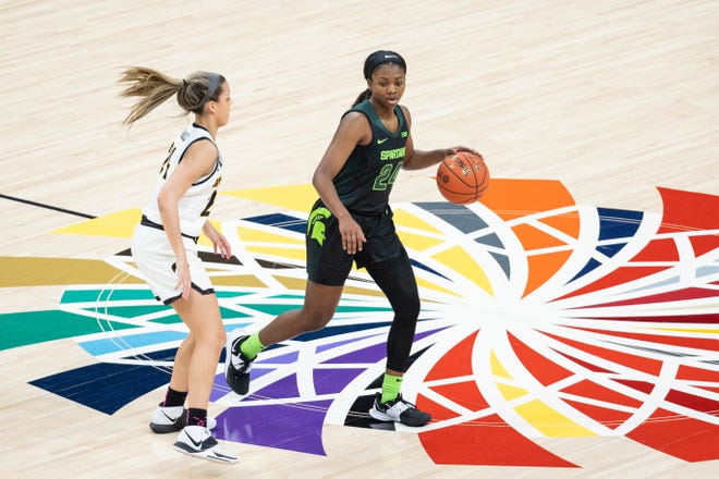 Mar 12, 2021; Indianapolis, IN, USA; Michigan State Spartans guard Nia Clouden (24) dribbles the ball while Iowa Hawkeyes guard Gabbie Marshall (24) defends in the second quarter at Bankers Life Fieldhouse. Mandatory Credit: Trevor Ruszkowski-USA TODAY Sports