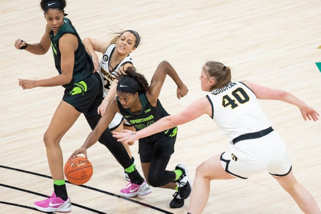 Mar 12, 2021; Indianapolis, Indiana, USA; Michigan State Spartans guard Nia Clouden (24) dribbles between Iowa Hawkeyes guard Gabbie Marshall (24) and center Sharon Goodman (40) in the second quarter at Bankers Life Fieldhouse. Mandatory Credit: Trevor Ruszkowski-USA TODAY Sports