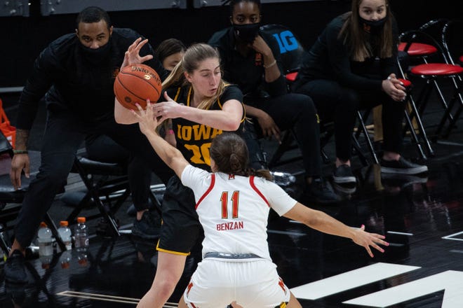 Mar 13, 2021; Indianapolis, IN, USA; Maryland Terrapins guard Katie Benzan (11) hits the ball away from Iowa Hawkeyes guard Kate Martin (20) in the second quarter at Bankers Life Fieldhouse. Mandatory Credit: Trevor Ruszkowski-USA TODAY Sports