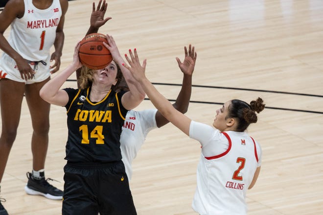 Mar 13, 2021; Indianapolis, IN, USA; Iowa Hawkeyes guard McKenna Warnock (14) shoots the ball while Maryland Terrapins forward Mimi Collins (2) defends in the third quarter at Bankers Life Fieldhouse. Mandatory Credit: Trevor Ruszkowski-USA TODAY Sports