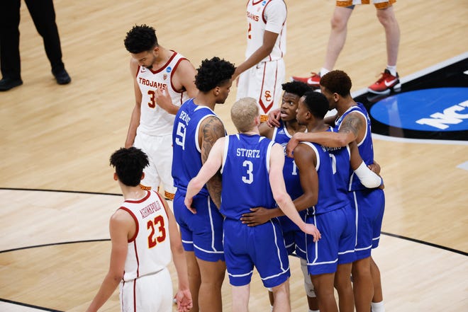 Drake players huddle around guard Joseph Yesufu (1) during their game against USC in the first round of the 2021 NCAA Tournament on Saturday, March 20, 2021, at Bankers Life Fieldhouse in Indianapolis, Ind.