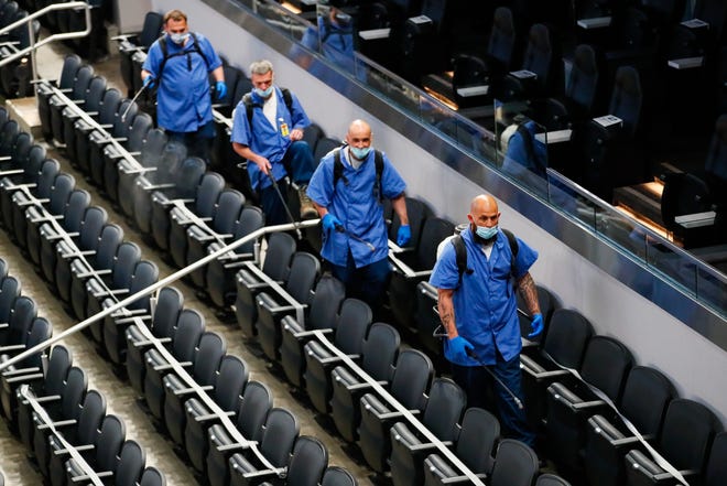 Cleaning crews prepare the stadium for fans before the USC vs. Drake game during the first round of the 2021 NCAA Tournament on Saturday, March 20, 2021, at Bankers Life Fieldhouse in Indianapolis, Ind.