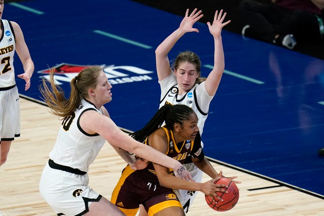 Central Michigan guard Anika Weekes, center, drives between Iowa center Sharon Goodman, left, and guard Kate Martin, right, during the second half of a college basketball game in the first round of the women's NCAA tournament at the Alamodome, Sunday, March 21, 2021, in San Antonio.