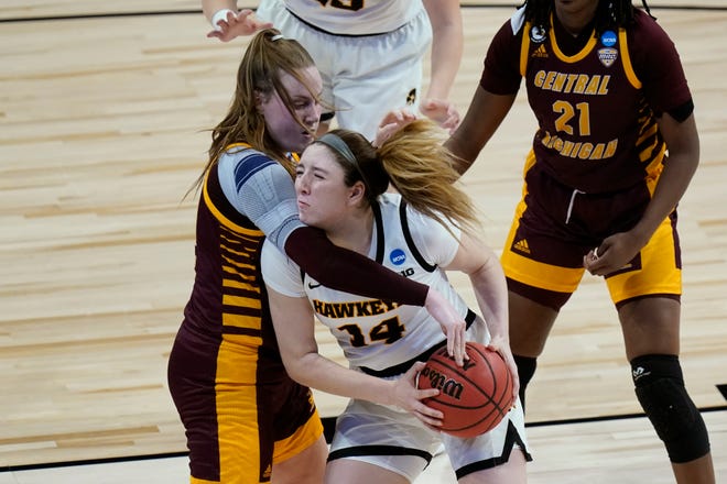 Iowa guard McKenna Warnock (14) is fouled by Central Michigan forward Kyra Bussell, left, during the second half of a college basketball game in the first round of the women's NCAA tournament at the Alamodome, Sunday, March 21, 2021, in San Antonio.