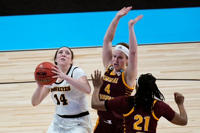 Iowa guard McKenna Warnock (14) drives to the basket ahead of Central Michigan guard Maddy Watters (4) and center Jahari Smith (21) during the second half of a college basketball game in the first round of the women's NCAA tournament at the Alamodome, Sunday, March 21, 2021, in San Antonio.