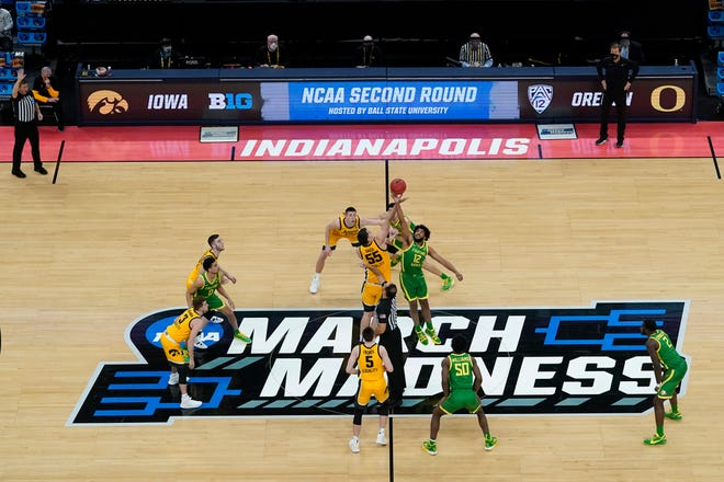 Iowa's Luka Garza (55) and Oregon's Chandler Lawson (13) tipoff for a second-round game in the NCAA men's college basketball tournament at Bankers Life Fieldhouse, Monday, March 22, 2021, in Indianapolis.
