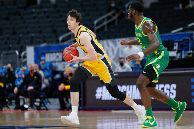 Iowa's Patrick McCaffery, left, handles the ball as Oregon's Eugene Omoruyi defends in the second round game of the 2021 NCAA Men's Basketball Tournament at Bankers Life Fieldhouse on March 22, 2021 in Indianapolis, Indiana.