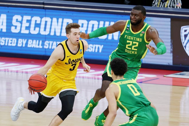 Iowa Hawkeyes guard Jordan Bohannon (3) dribbles as Oregon Ducks center Franck Kepnang (22) pursues during the first half in the second round of the 2021 NCAA Tournament, March 22, 2021, at Bankers Life Fieldhouse.