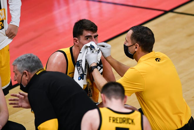 Iowa Hawkeyes athletic trainer Brad Floy helps center Luka Garza with a nosebleed during their game against the Oregon Ducks in the second round of the 2021 NCAA Tournament on Monday, March 22, 2021, at Bankers Life Fieldhouse in Indianapolis, Ind.