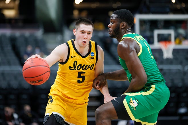 Iowa's CJ Fredrick (5) drives against Oregon's Eugene Omoruyi in the second round game of the 2021 NCAA Men's Basketball Tournament at Bankers Life Fieldhouse on March 22, 2021 in Indianapolis, Indiana.
