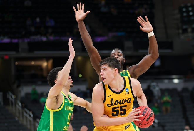 INDIANAPOLIS, INDIANA - MARCH 22: Luka Garza #55 of the Iowa Hawkeyes handles the ball defended by Chris Duarte #5 and Eugene Omoruyi #2 of the Oregon Ducks in the second round game of the 2021 NCAA Men's Basketball Tournament at Bankers Life Fieldhouse on March 22, 2021 in Indianapolis, Indiana.