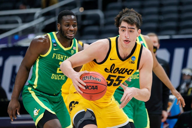 Iowa center Luka Garza (55) handles the ball as Oregon's Eugene Omoruyi defends in the second round game of the 2021 NCAA Men's Basketball Tournament at Bankers Life Fieldhouse on March 22, 2021 in Indianapolis, Indiana.