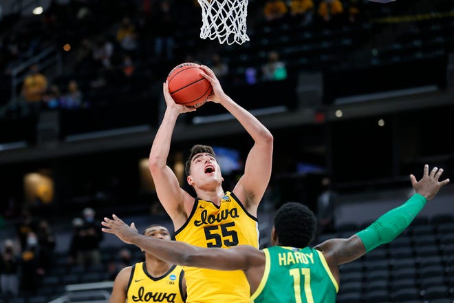 Iowa Hawkeyes center Luka Garza (55) drives to the basket against Oregon's Amauri Hardy (11) in the second round game of the 2021 NCAA Men's Basketball Tournament at Bankers Life Fieldhouse on March 22, 2021 in Indianapolis, Indiana.