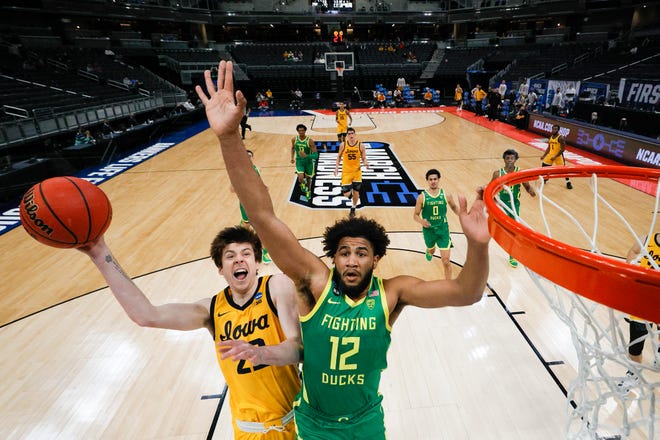 INDIANAPOLIS, INDIANA - MARCH 22: Patrick McCaffery #22 of the Iowa Hawkeyes drives to the basket defended by LJ Figueroa #12 of the Oregon Ducks in the second round game of the 2021 NCAA Men's Basketball Tournament at Bankers Life Fieldhouse on March 22, 2021 in Indianapolis, Indiana.