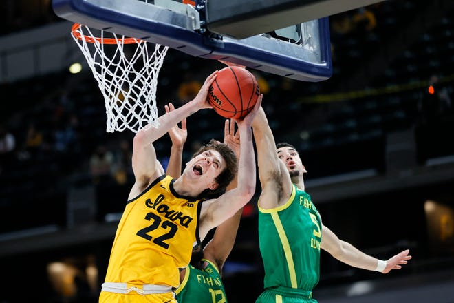 INDIANAPOLIS, INDIANA - MARCH 22: Patrick McCaffery #22 of the Iowa Hawkeyes drives to the basket defended by LJ Figueroa #12 and Chris Duarte #5 of the Oregon Ducks in the second round game of the 2021 NCAA Men's Basketball Tournament at Bankers Life Fieldhouse on March 22, 2021 in Indianapolis, Indiana.