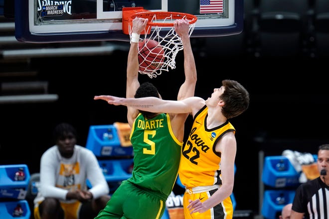 Oregon guard Chris Duarte (5) dunks on Iowa forward Patrick McCaffery (22) during the first half of a men's college basketball game in the second round of the NCAA tournament at Bankers Life Fieldhouse in Indianapolis, Monday, March 22, 2021.