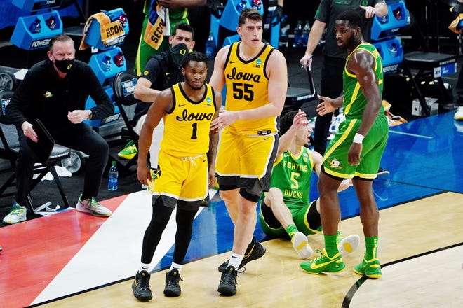Mar 22, 2021; Indianapolis, Indiana, USA; Iowa Hawkeyes center Luka Garza (55) guides guard Joe Toussaint (1) away from Oregon Ducks guard Chris Duarte (5) as he is helped up by forward Eugene Omoruyi (2) during the first half in the second round of the 2021 NCAA Tournament at Bankers Life Fieldhouse.