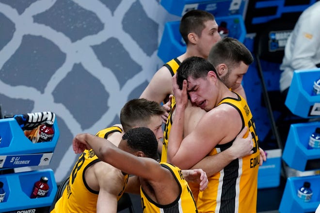 Iowa's Luka Garza (55) hugs teammate Connor McCaffery following a second-round game against Oregon in the NCAA men's college basketball tournament at Bankers Life Fieldhouse, Monday, March 22, 2021, in Indianapolis. Oregon won 95-80.