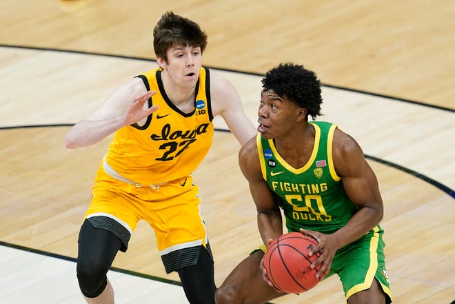 Oregon's Eric Williams Jr. (50) go to the basket against Iowa's Patrick McCaffery (22) during the first half of a second-round game in the NCAA men's college basketball tournament at Bankers Life Fieldhouse, Monday, March 22, 2021, in Indianapolis.