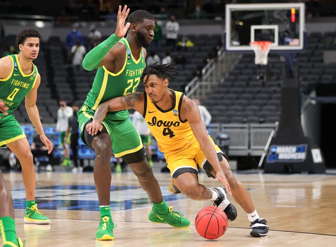 INDIANAPOLIS, INDIANA - MARCH 22: Ahron Ulis #4 of the Iowa Hawkeyes drives around Franck Kepnang #22 of the Oregon Ducks in the second round game of the 2021 NCAA Men's Basketball Tournament at Bankers Life Fieldhouse on March 22, 2021 in Indianapolis, Indiana.