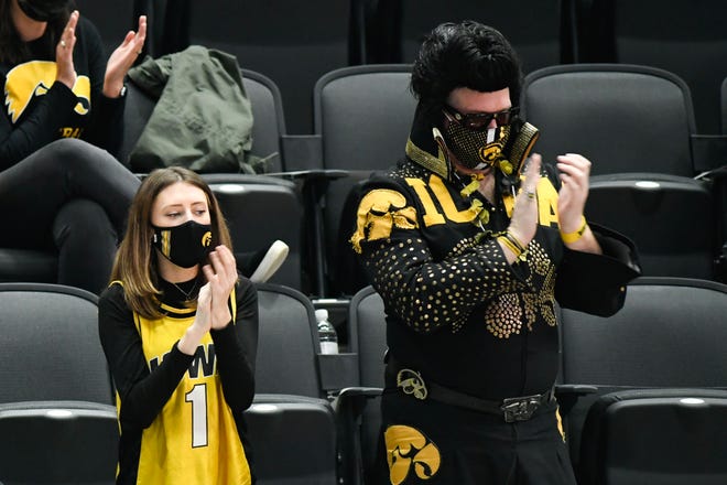 "Hawkeye Elvis" Greg Suckow and other Iowa Hawkeyes fans sing to the fight song during a timeout in the second round of the 2021 NCAA Tournament against the Oregon Ducks on Monday, March 22, 2021, at Bankers Life Fieldhouse in Indianapolis, Ind.