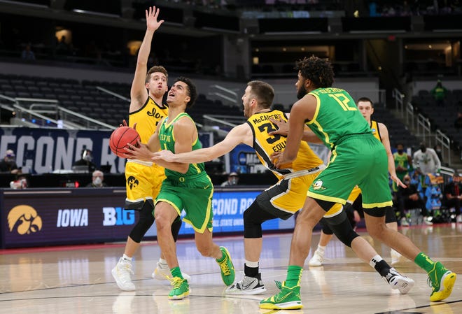 INDIANAPOLIS, INDIANA - MARCH 22: Will Richardson #0 of the Oregon Ducks is fouled by Connor McCaffery #30 of the Iowa Hawkeyes in the second round game of the 2021 NCAA Men's Basketball Tournament at Bankers Life Fieldhouse on March 22, 2021 in Indianapolis, Indiana.