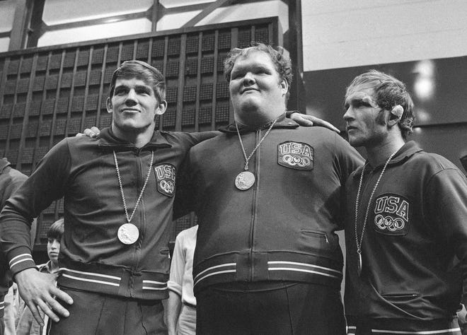 Three Americans wrestlers who won medals at the Olympic Games freestyle wrestling competitions pose together at the medal award ceremony Sept. 1, 1972, in Munich. From left: Ben Peterson, of Comstock, Wis, a gold medal winner in the 90 kilos class, Chris Taylor, of Dowagiac, Mich, a bronze medal in the over 100 kilos class, and Dan Gable, of Waterloo, Iowa, a gold medal in the 68 kilos class. (AP Photo).