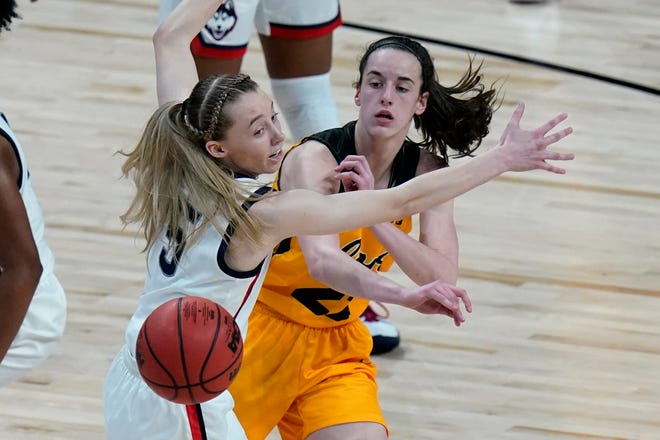 Iowa guard Caitlin Clark (22) passes the ball around UConn guard Paige Bueckers (5) during the first half of a college basketball game in the Sweet 16 round of the women's NCAA tournament at the Alamodome in San Antonio, Saturday, March 27, 2021.