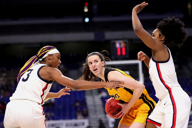 Iowa's Caitlin Clark drives to the basket between UConn's Aaliyah Edwards (3) and Christyn Williams, right, during the first half in the Sweet 16 round of the NCAA Women's Basketball Tournament at the Alamodome on March 27, 2021 in San Antonio, Texas.