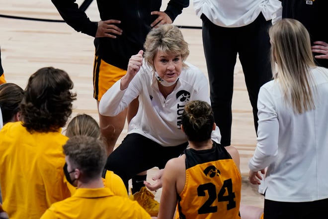 Iowa head coach Lisa Buder, center, talks to her players during the first half of a college basketball game against UConn in the Sweet 16 round of the women's NCAA tournament at the Alamodome in San Antonio, Saturday, March 27, 2021.