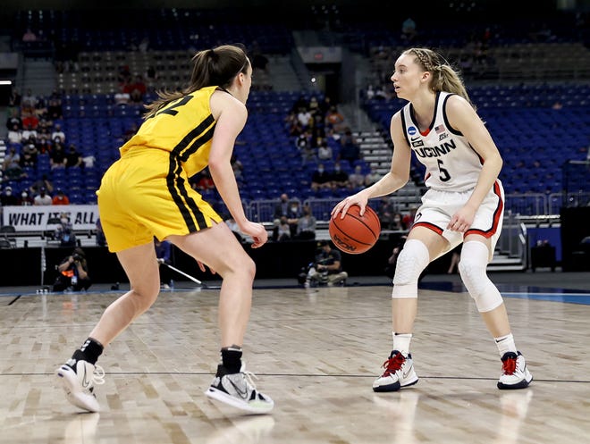 UConn's Paige Bueckers (5) takes the ball as Iowa's Caitlin Clark (22) defends in the first half during the Sweet 16 round of the NCAA Women's Basketball Tournament at the Alamodome on March 27, 2021 in San Antonio, Texas.