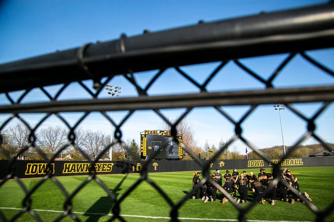 Iowa Hawkeyes players huddle up in the outfield after a NCAA Big Ten Conference softball game against Northwestern, Saturday, April 17, 2021, at Bob Pearl Field in Iowa City, Iowa.