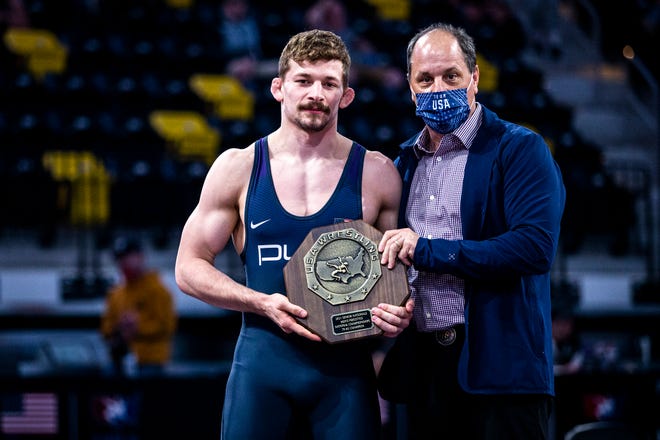 Taylor Lujan is presented with his stop sign trophy after winning via medical forfeit at 79 kg during the UWW Senior National freestyle wrestling championships, Saturday, May 1, 2021, at the Xtream Arena in Coralville, Iowa.