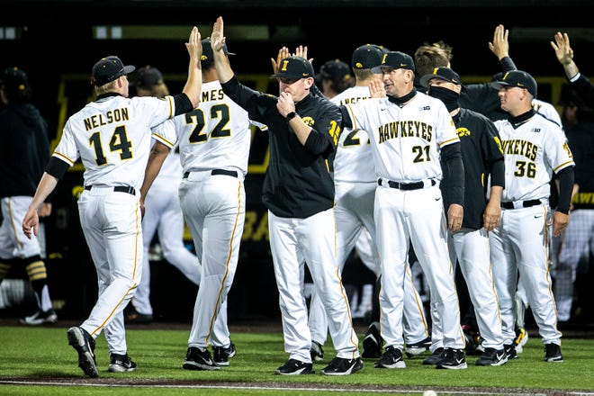 Iowa associate head coach Marty Sutherland and Iowa head coach Rick Heller (21) celebrates with players after a NCAA Big Ten Conference baseball game against Illinois, Friday, May 14, 2021, at Duane Banks Field in Iowa City, Iowa.