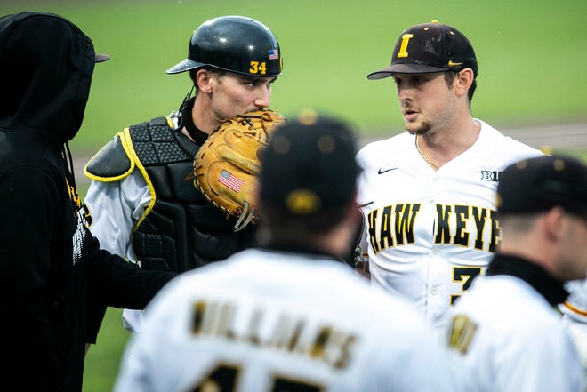 Iowa's Austin Martin (34) talks with pitcher Trenton Wallace, right, during a NCAA Big Ten Conference baseball game against Illinois, Friday, May 14, 2021, at Duane Banks Field in Iowa City, Iowa.