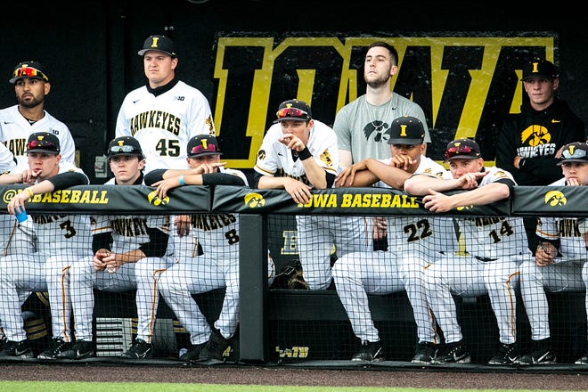 Iowa Hawkeyes players including Connor McCaffery, fifth from right in gray, watch from the dugout during a NCAA Big Ten Conference baseball game against Illinois, Friday, May 14, 2021, at Duane Banks Field in Iowa City, Iowa.