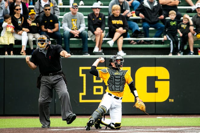 The home plate umpire calls a strike as Iowa's Austin Martin (34) catches during a NCAA Big Ten Conference baseball game against Illinois, Sunday, May 16, 2021, at Duane Banks Field in Iowa City, Iowa.