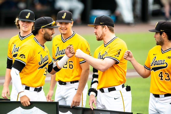 Iowa's Matthew Sosa (31) bumps fists with teammate Hunter Lee, second from right, during a senior day ceremony before a NCAA Big Ten Conference baseball game against Illinois, Sunday, May 16, 2021, at Duane Banks Field in Iowa City, Iowa.