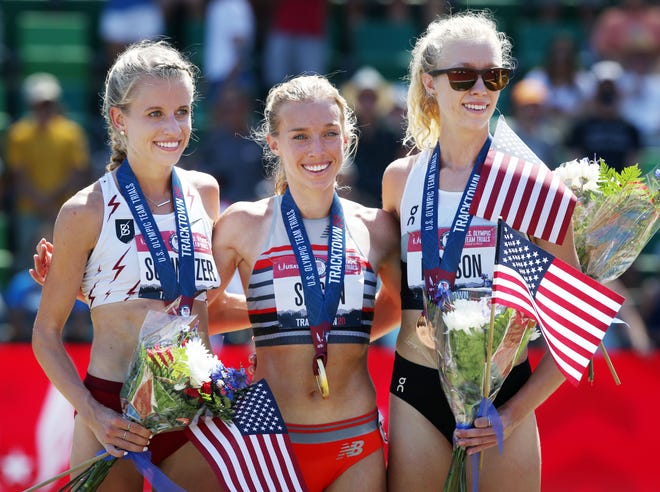 Winner of the 10,000 meters, Emily Sisson, center, climbs on the awards platform with Karissa Schweizer, left, silver medalist and  Alicia Monson, bronze   during the Olympic Track and Field Trials Saturday morning.