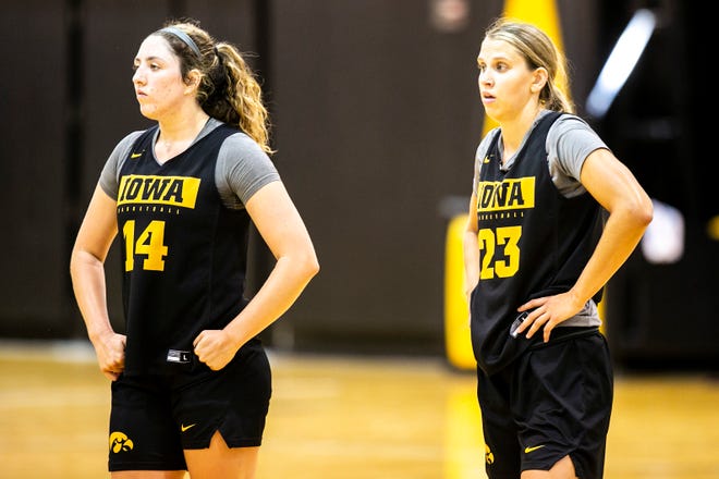 Iowa's McKenna Warnock (14) and Iowa forward Logan Cook (23) listen to instructions during a summer Hawkeyes women's basketball practice, Thursday, July 1, 2021, at Carver-Hawkeye Arena in Iowa City, Iowa.