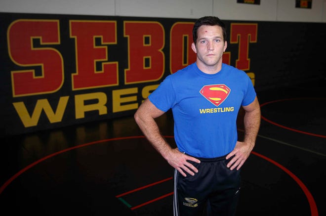 T.J. Sebolt, owner and head coach of the Sebolt Wrestling Academy, poses for a photo in the wrestling room of the Grant Robbins Fieldhouse in Jefferson on Tuesday, July 13, 2021.