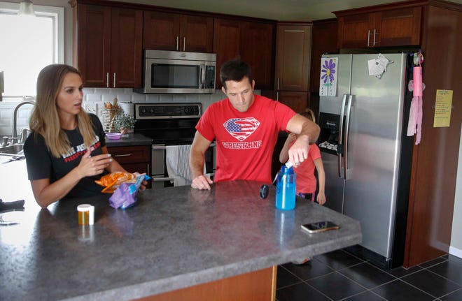 Four-time Iowa high school wrestling champion T.J. Sebolt and his wife, Bethany, share stories about the early days of the Sebolt Wrestling Academy from the kitchen of their home in Jefferson on Tuesday, July 13, 2021.