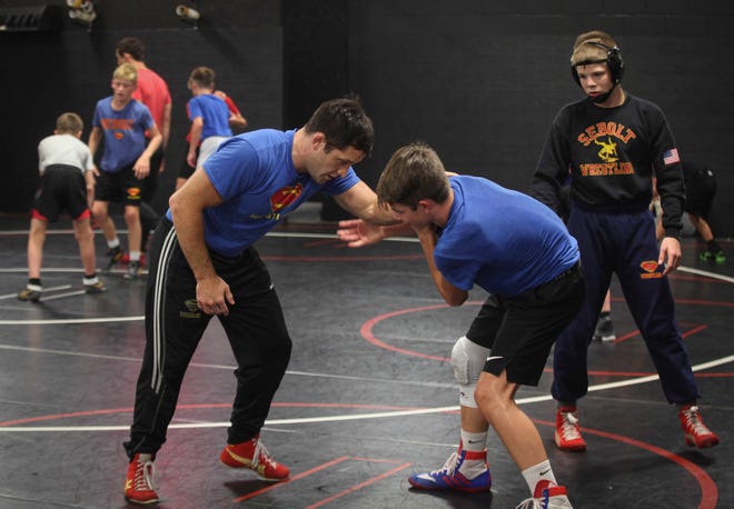 T.J. Sebolt, owner and head coach of the Sebolt Wrestling Academy, left, coaches his wrestlers during practice in the wrestling room of the Grant Robbins Fieldhouse in Jefferson on Tuesday, July 13, 2021.