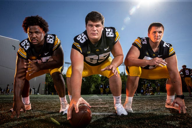 From left Iowa offensive linemen Justin Britt (63), Tyler Linderbaum (65) and Cody Ince (73) pose for a photo during the Iowa Hawkeye football media day on Friday, Aug. 13, 2021 in Iowa City, IA.