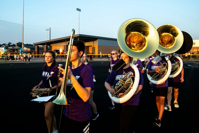 Members of the Iowa City Liberty marching band walk to the field before a varsity high school football game, Friday, Aug. 27, 2021, at Liberty High School in North Liberty, Iowa.